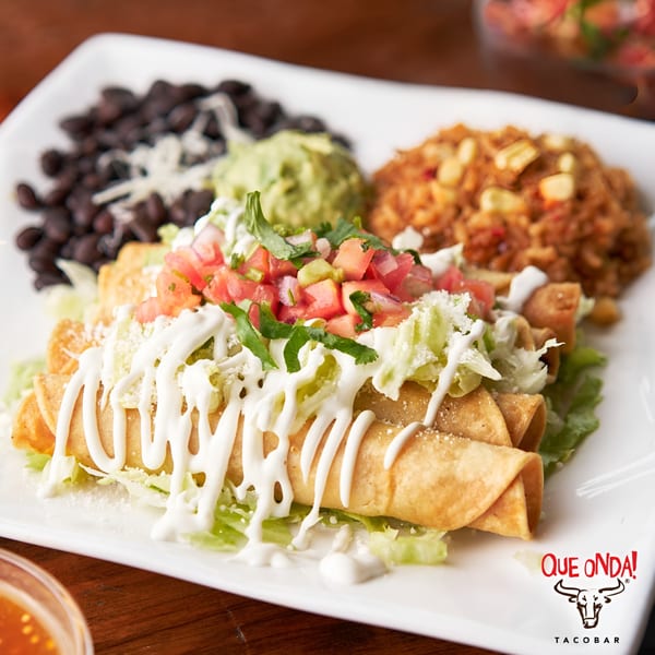Que Onda Tacobar's taquitos with lettuce, pico de gallo, sour cream, rice, black beans, and guacamole.