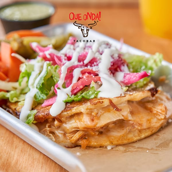 Que Onda Tacobar's quesadilla with chicken, lettuce, pickled onions, crema, and a side of pickled vegetables.